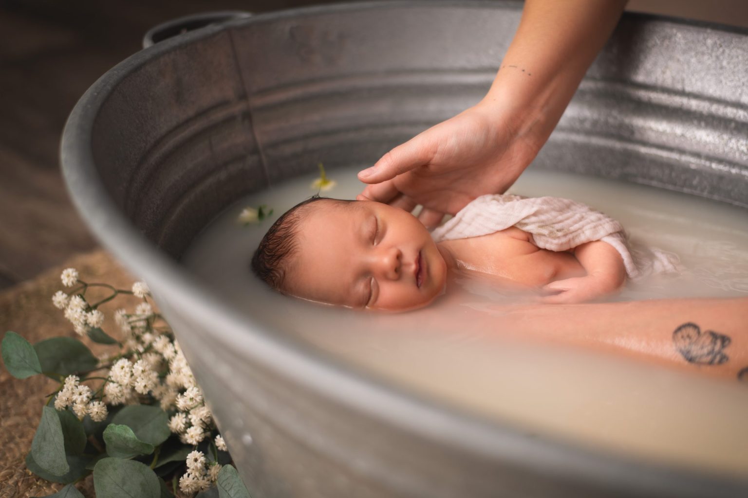 Nouveau-n&eacute; lov&eacute; dans une bassine en zinc, une main soutenant d&eacute;licatement sa t&ecirc;te &ndash; s&eacute;ance bain envelopp&eacute; &agrave; Tournai